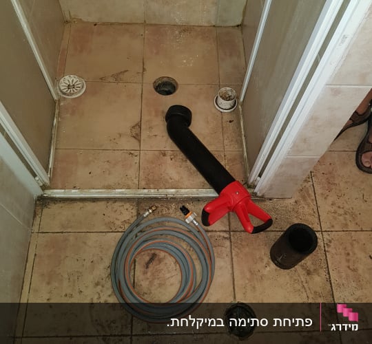 צינור מים וכלי עבודה על רצפת מקלחת